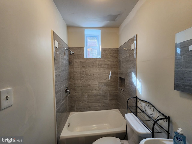 bathroom with toilet and tiled shower / bath combo