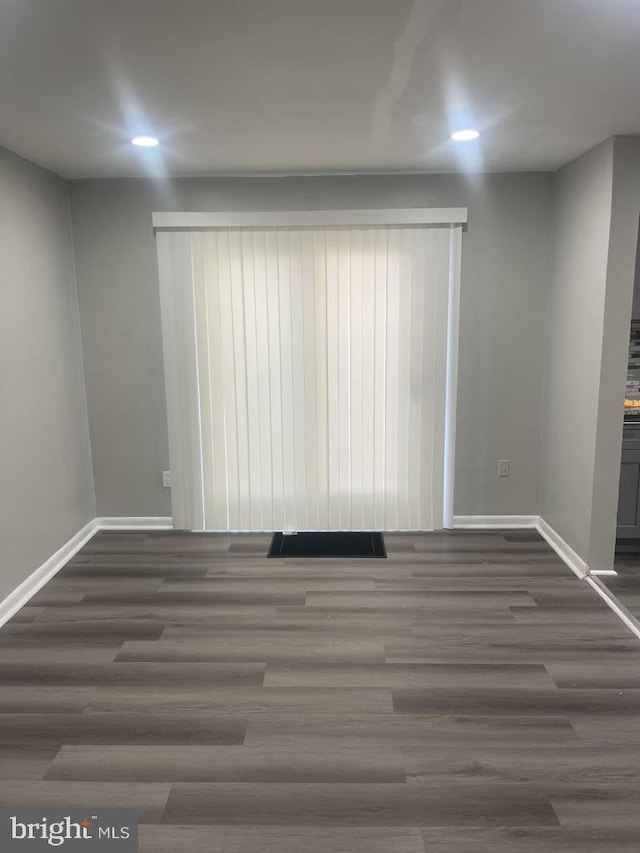 unfurnished room with dark wood-type flooring