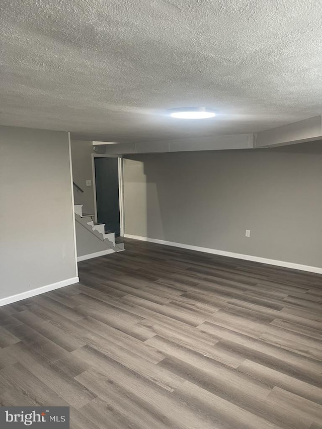 basement featuring a textured ceiling and wood-type flooring