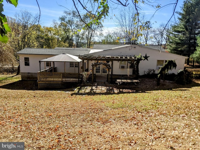 rear view of property featuring a deck and a yard