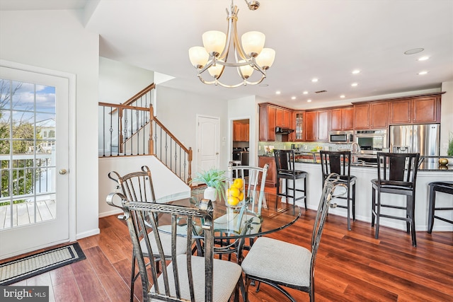 dining area with dark hardwood / wood-style flooring and a chandelier