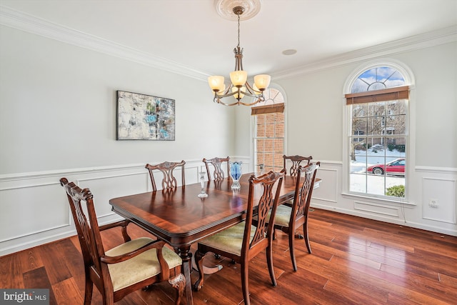 dining space featuring ornamental molding, dark wood-type flooring, and a notable chandelier