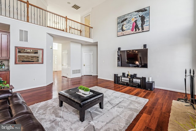 living room featuring dark hardwood / wood-style floors and a high ceiling