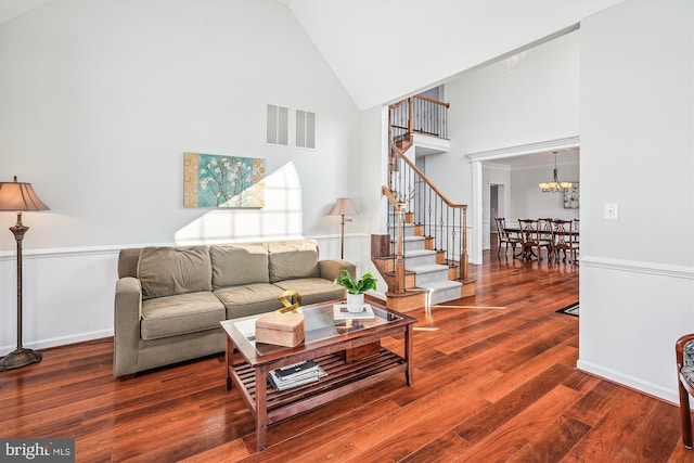 living room featuring a chandelier, high vaulted ceiling, and wood-type flooring