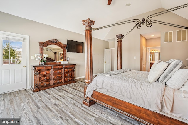 bedroom featuring light hardwood / wood-style flooring, ensuite bath, ceiling fan, and lofted ceiling