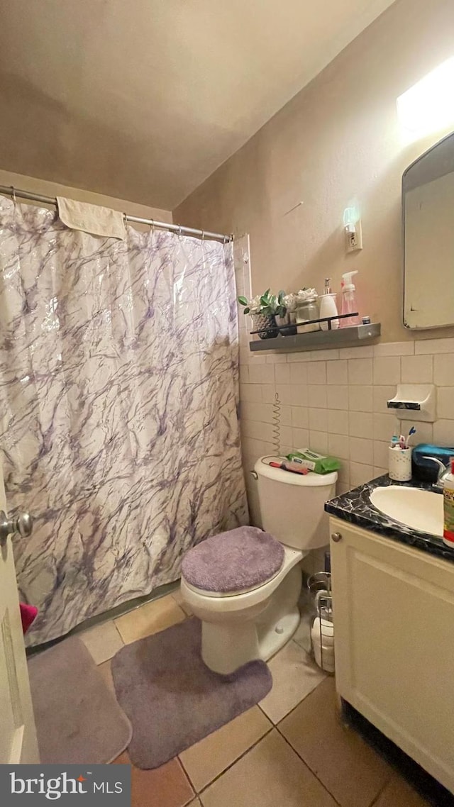 bathroom featuring vanity, toilet, tile walls, and tile patterned flooring