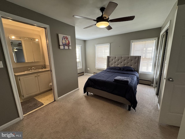 carpeted bedroom featuring ensuite bath, ceiling fan, sink, and a baseboard heating unit