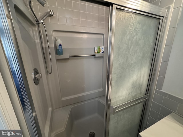 bathroom with an enclosed shower and tile walls