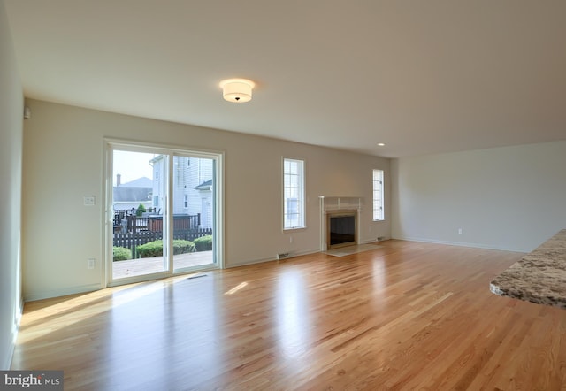 unfurnished living room with light hardwood / wood-style floors and plenty of natural light