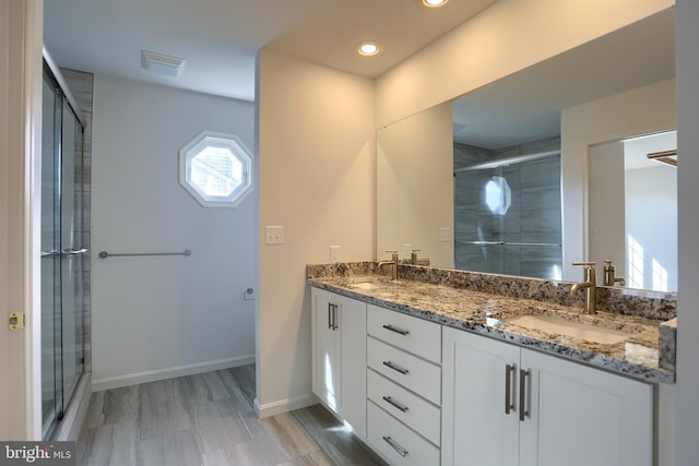 bathroom featuring vanity and a shower with door