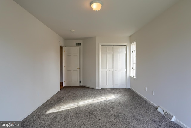 unfurnished bedroom featuring carpet flooring and a closet