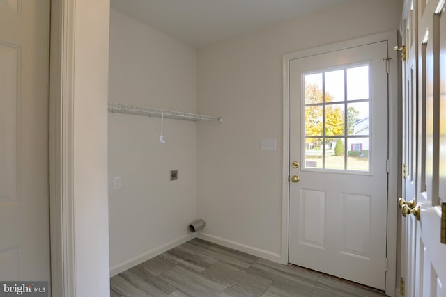 clothes washing area with light hardwood / wood-style flooring and electric dryer hookup