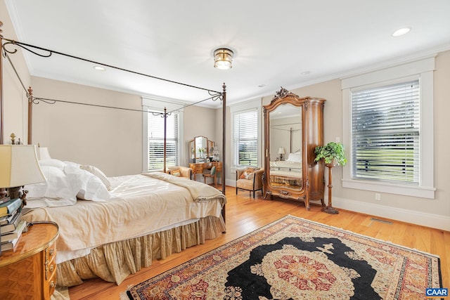 bedroom with light hardwood / wood-style floors and ornamental molding