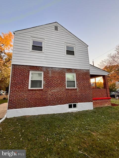 view of side of home with a lawn