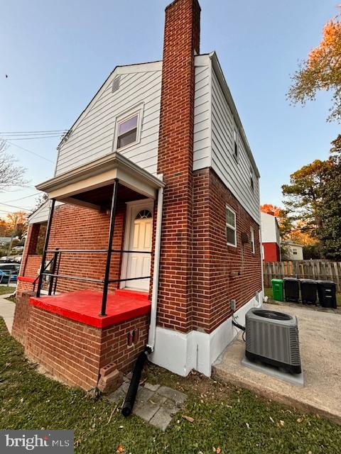 view of side of property with a patio area and central AC unit