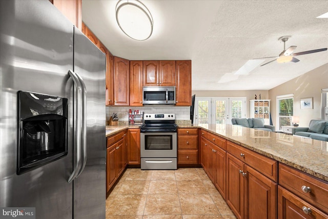702 Ocean Pkwy, Ocean Pines, MD 21811 - kitchen featuring appliances with stainless steel finishes, brown cabinetry, open floor plan, light stone counters, and backsplash