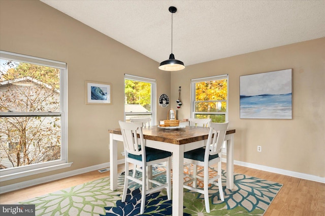 702 Ocean Pkwy, Ocean Pines, MD 21811 - dining area with light wood-type flooring, baseboards, a textured ceiling, and lofted ceiling