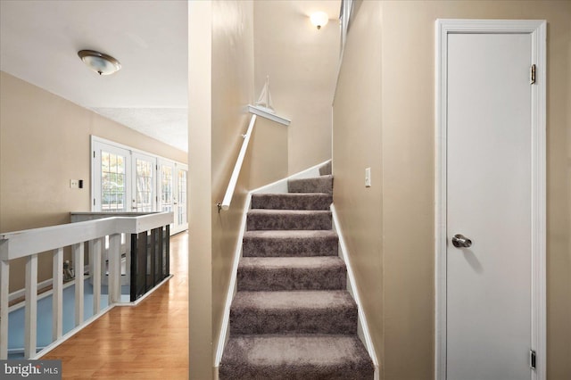 stairway featuring wood-type flooring and french doors