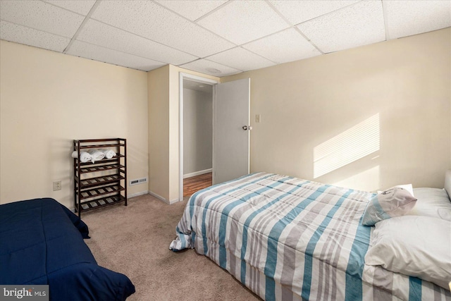 bedroom featuring a paneled ceiling and carpet floors