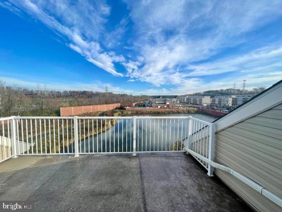 view of patio featuring a balcony and a water view