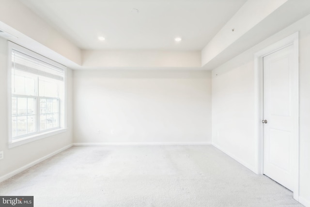 unfurnished room with light carpet, recessed lighting, and baseboards