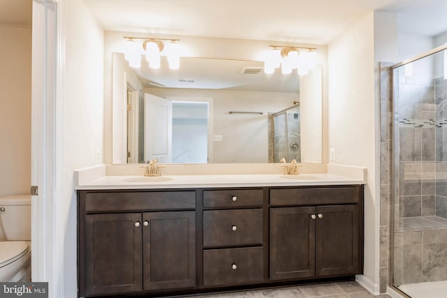 full bath with a sink, toilet, and double vanity