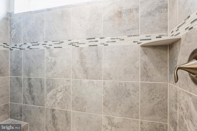 interior details featuring a tile shower