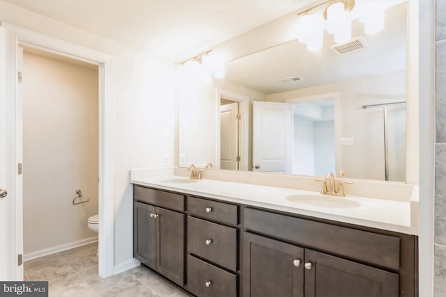 full bathroom with toilet, double vanity, a sink, and visible vents