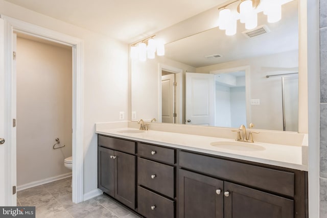 bathroom featuring visible vents, a sink, toilet, and double vanity