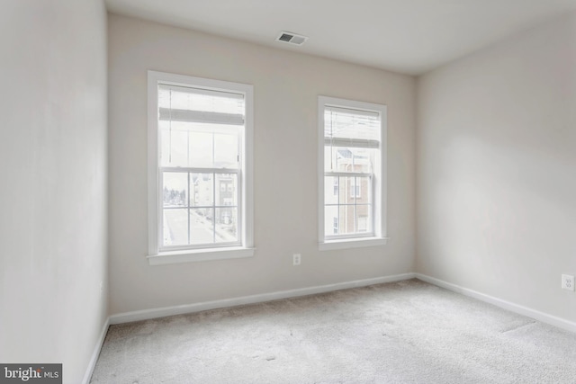 spare room featuring carpet floors, baseboards, and visible vents