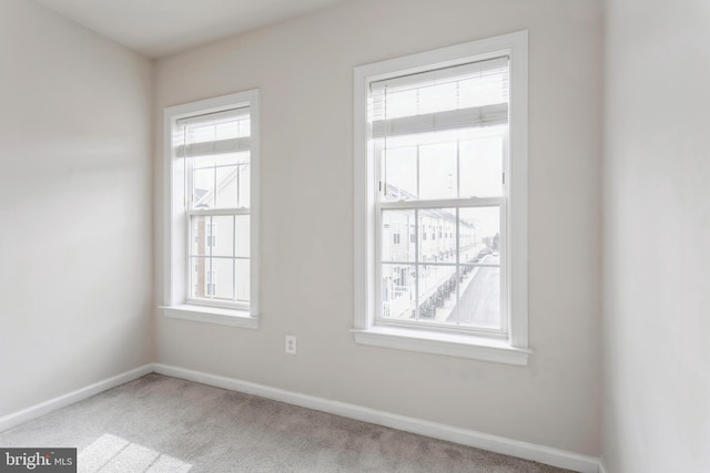 spare room featuring carpet flooring and baseboards