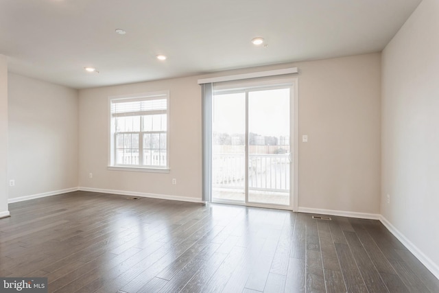 spare room featuring dark wood-style floors, baseboards, and recessed lighting