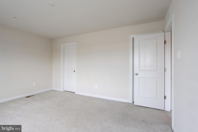 interior space featuring baseboards, visible vents, and light colored carpet