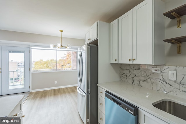 kitchen with light stone counters, a healthy amount of sunlight, white cabinetry, and appliances with stainless steel finishes