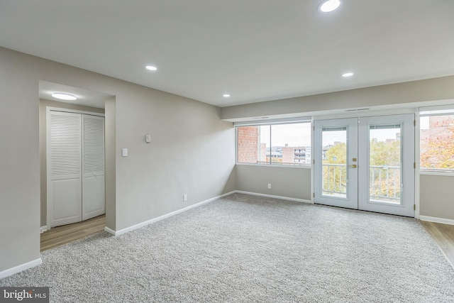 carpeted spare room featuring french doors