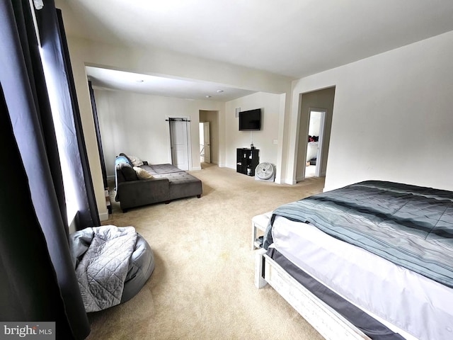 carpeted bedroom featuring a barn door