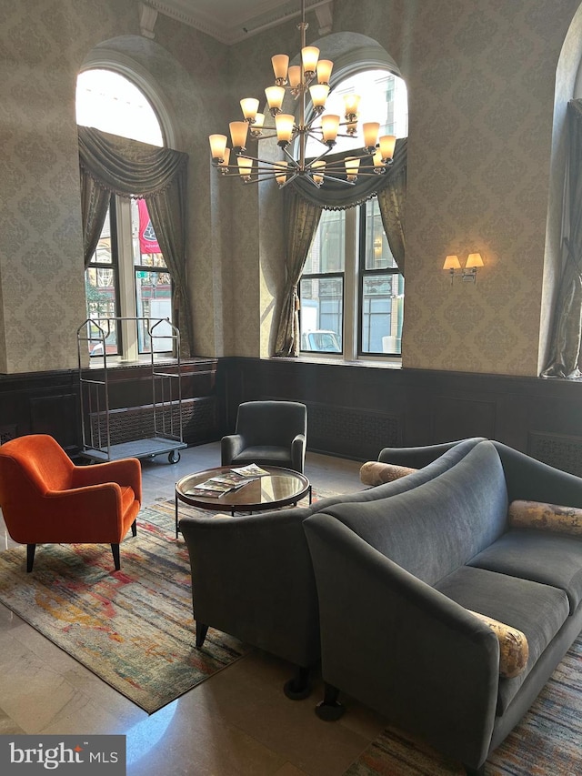 living room with ornamental molding and a chandelier