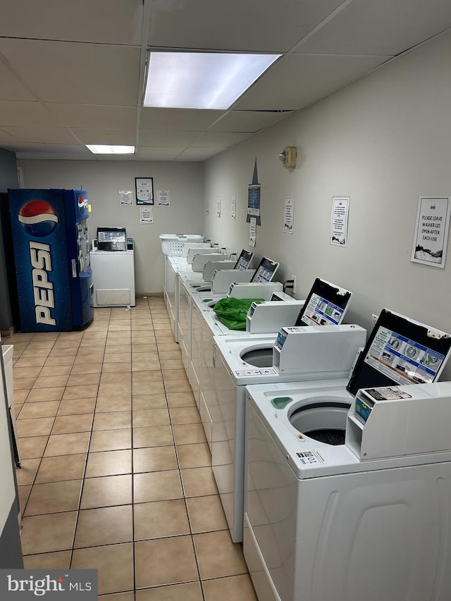 clothes washing area with washer and dryer and light tile patterned flooring