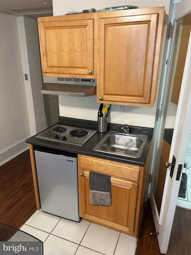 kitchen with stainless steel dishwasher, sink, electric cooktop, and light tile patterned floors