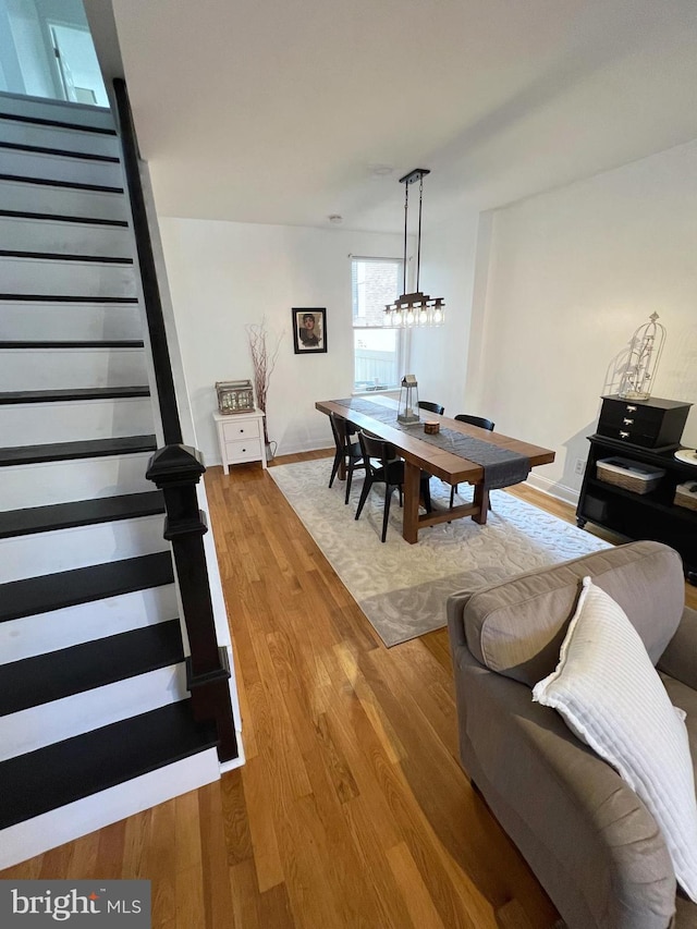 dining space with wood-type flooring and a notable chandelier