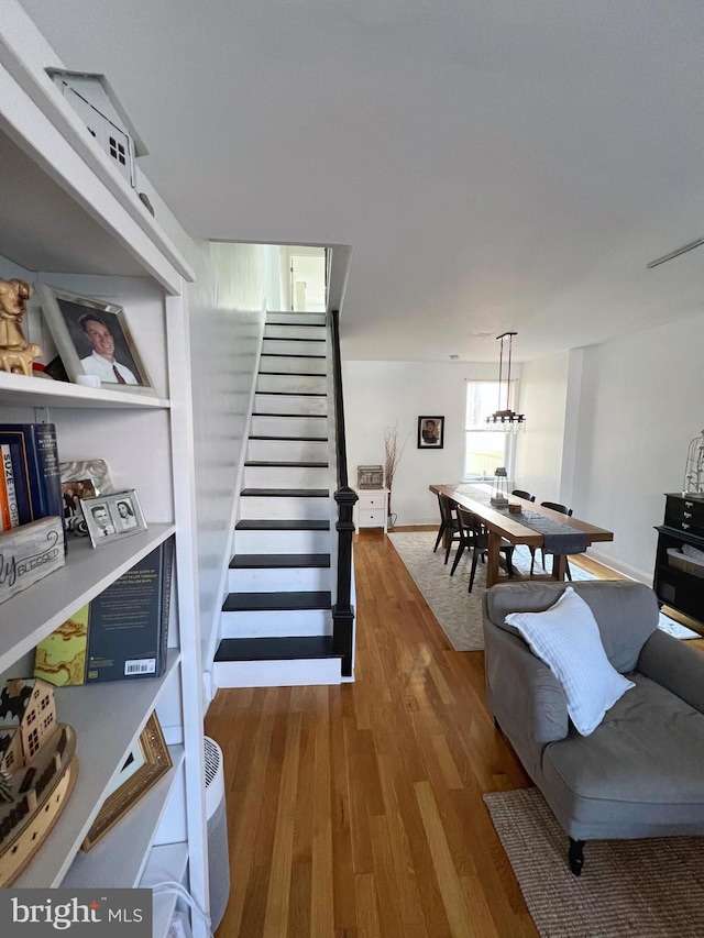 staircase featuring a chandelier and hardwood / wood-style flooring