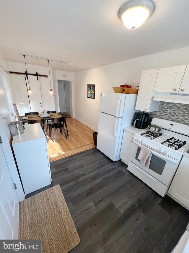 kitchen featuring hanging light fixtures, white appliances, white cabinets, dark wood-type flooring, and decorative backsplash