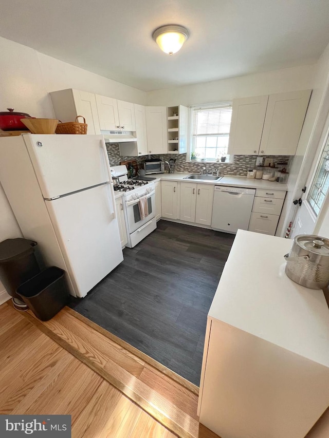 kitchen featuring white appliances, dark hardwood / wood-style floors, white cabinetry, and sink