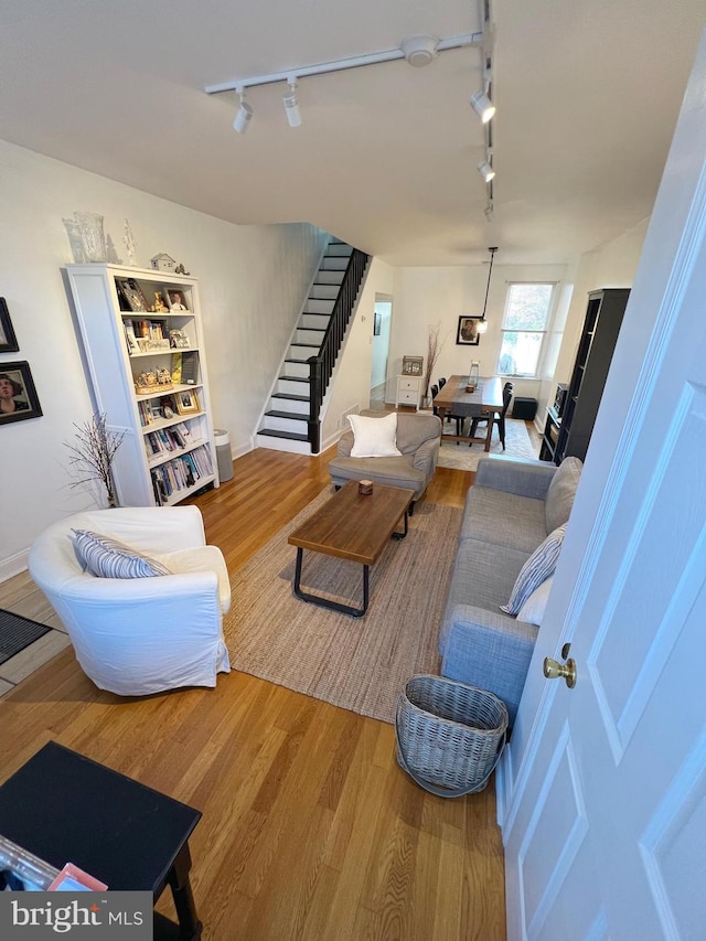 living room with wood-type flooring and track lighting