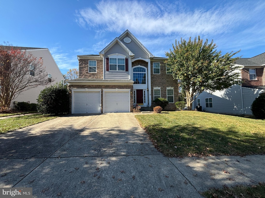 view of property with a garage and a front lawn