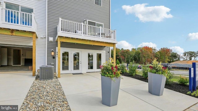 view of patio with a balcony, central AC, and french doors