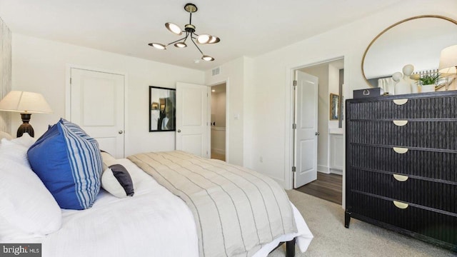 carpeted bedroom with a notable chandelier