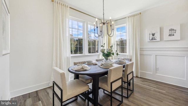 dining space featuring dark hardwood / wood-style flooring and an inviting chandelier