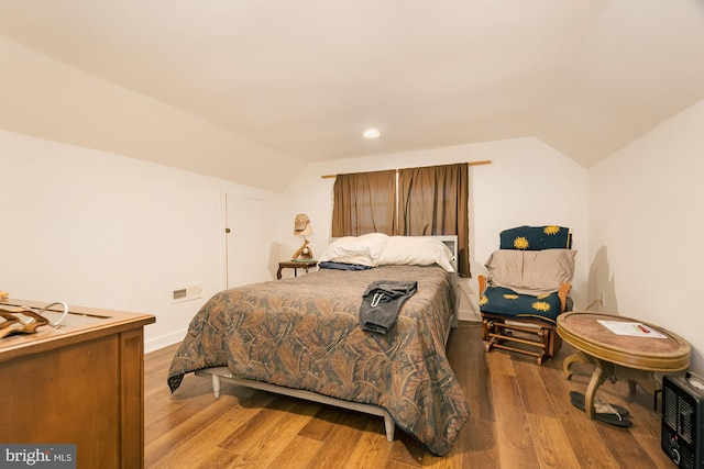 bedroom with vaulted ceiling and light hardwood / wood-style flooring