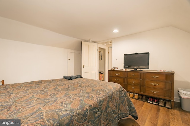 bedroom featuring light wood-type flooring and lofted ceiling